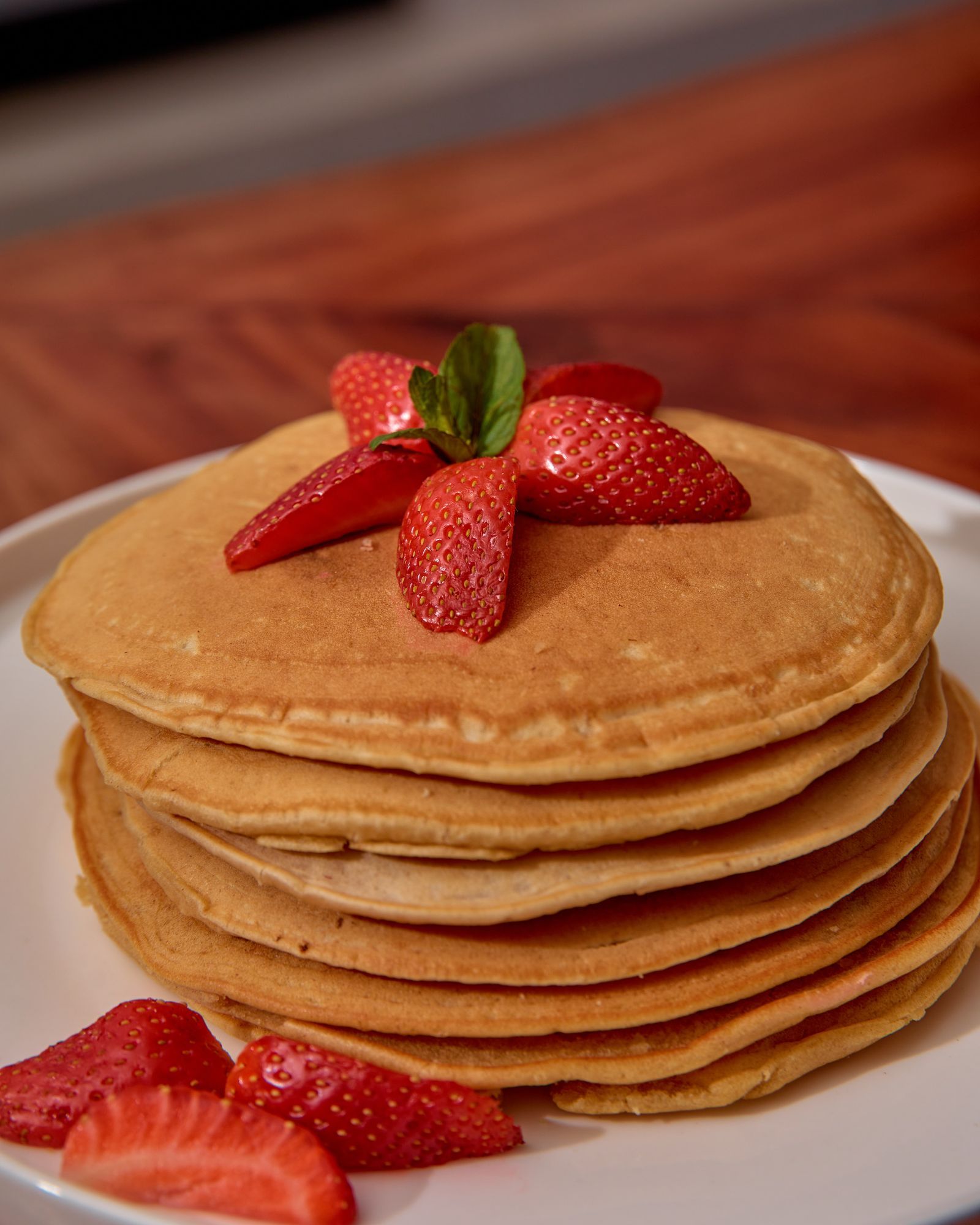 Ein Stapel goldbrauner Pfannkuchen mit frischen Erdbeeren
